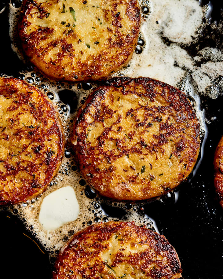 potato and caraway seed cakes in a cast iron pan sizzling