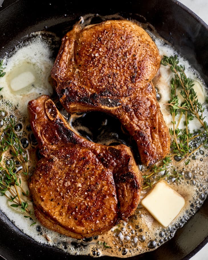 Pork chops in a skillet with butter and thyme