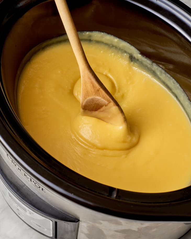 lemon curd being stirred in a slow cooker