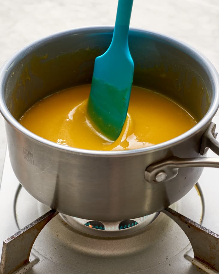 lemon curd being stirred in a pan on heat