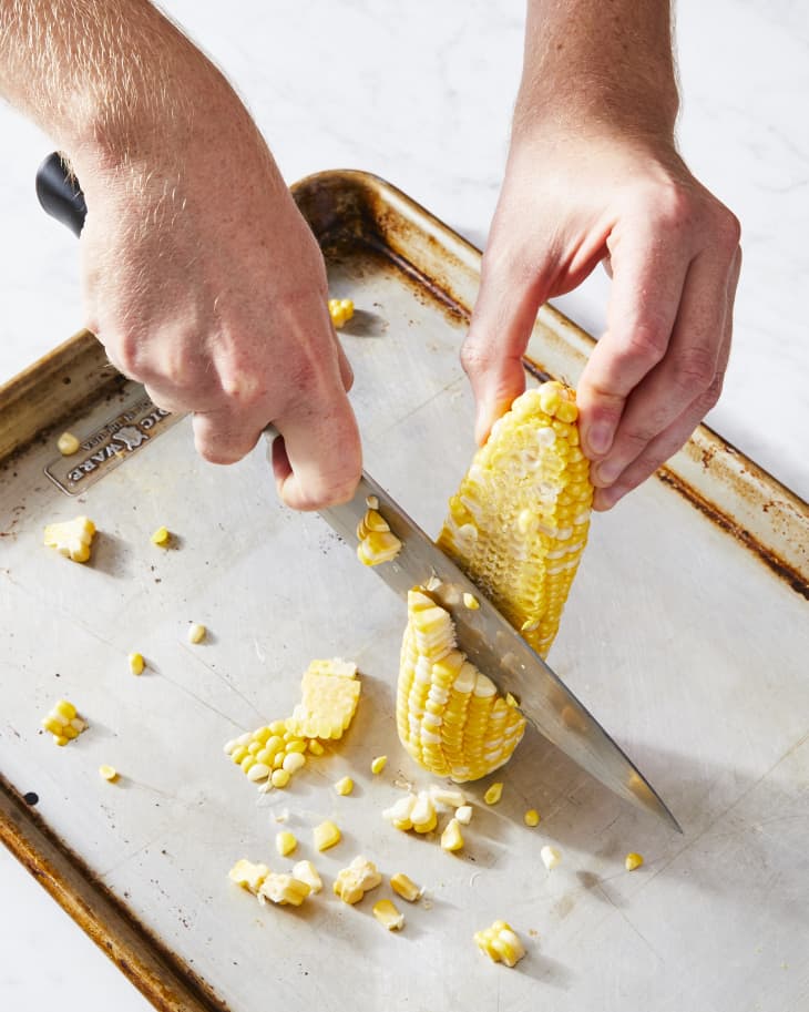 cutting corn on baking sheet