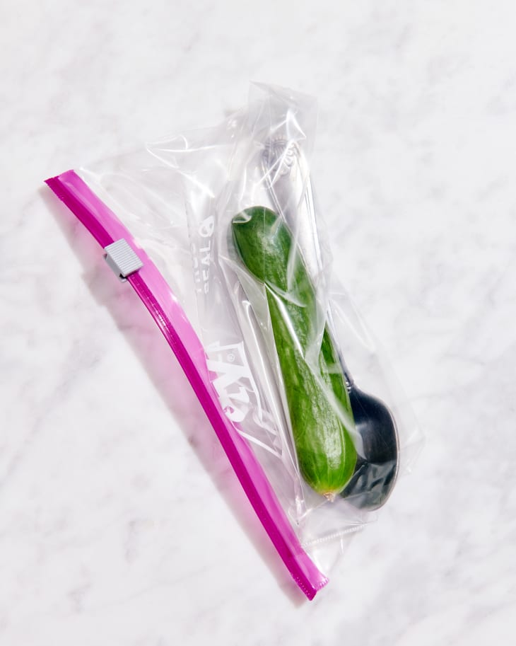 persian cucumber in plastic bag with spoon on marble counter