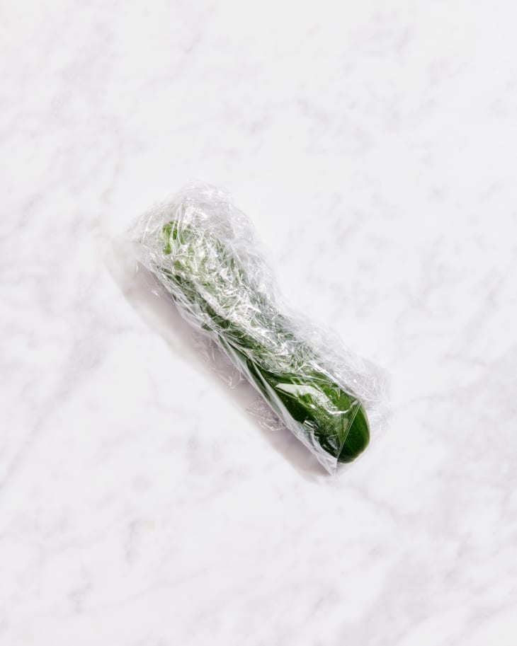 persian cucumber in plastic wrap on marble counter
