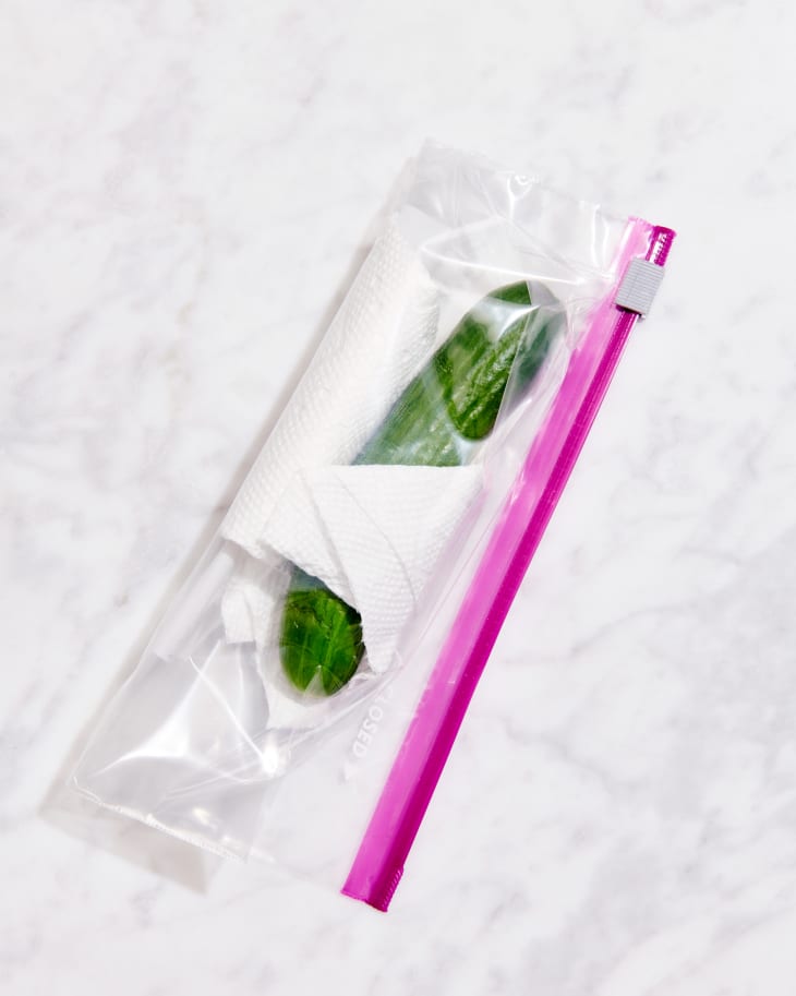 persian cucumber in plastic bag and paper towel on marble counter