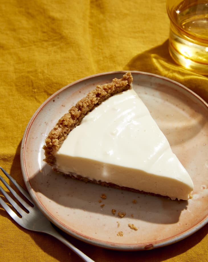 cheesecake on plate with fork and water