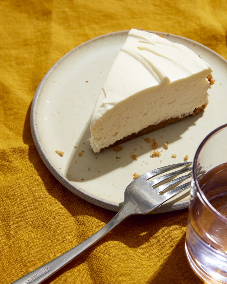 cheesecake on plate with fork and water