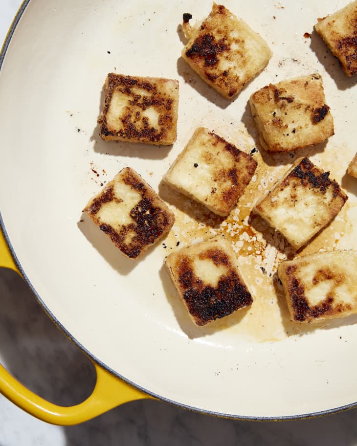 tofu being crisped in frying pan