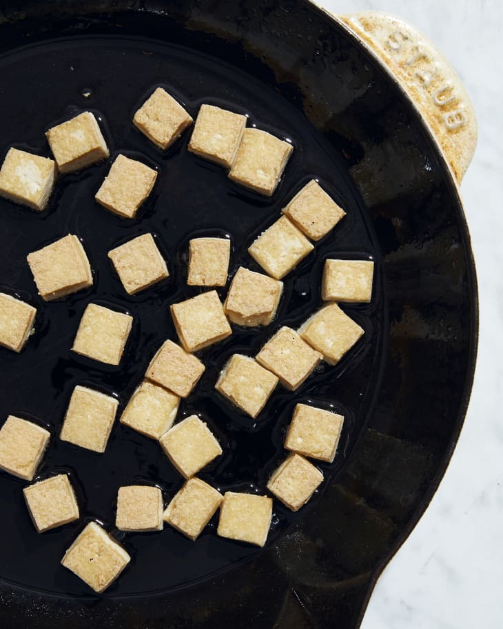 tofu being crisped in frying pan