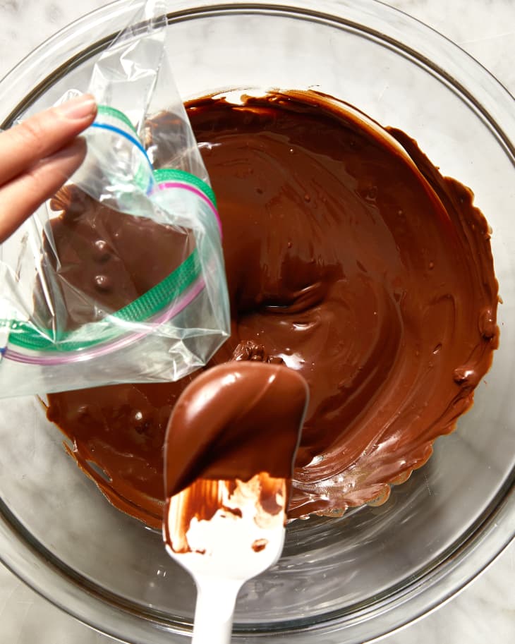 chocolate in a bowl being scooped into. a bag