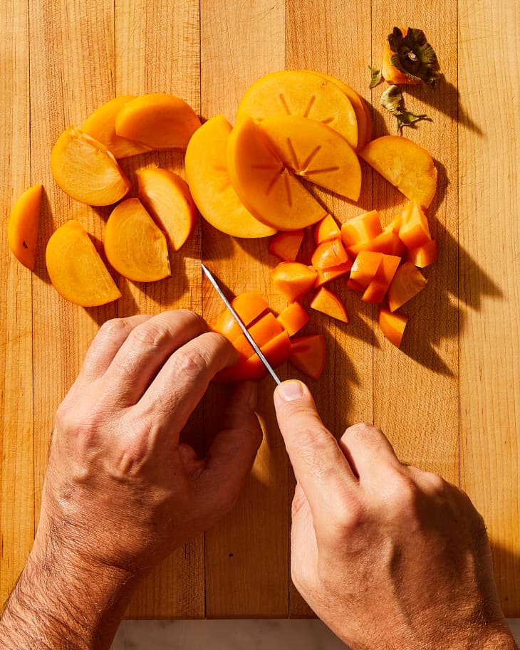 someone slicing persimmon into chunks