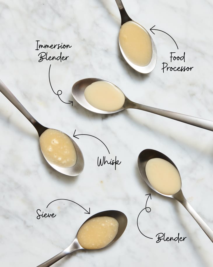 5 spoons on a marble surface, each one with gravy in it