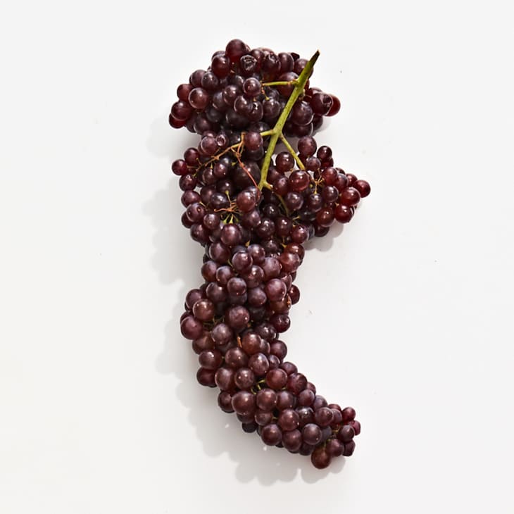 Champagne grapes on a white surface.