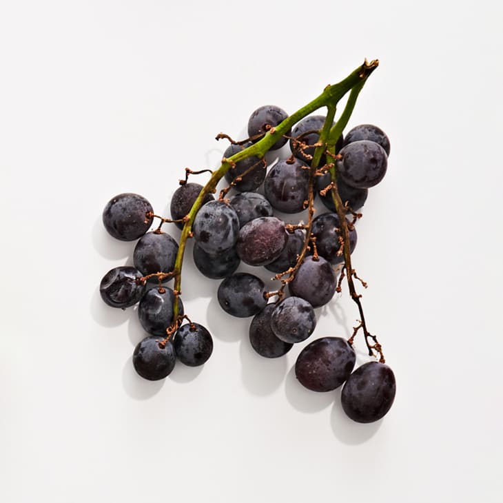 Kyoho grapes on a white surface.