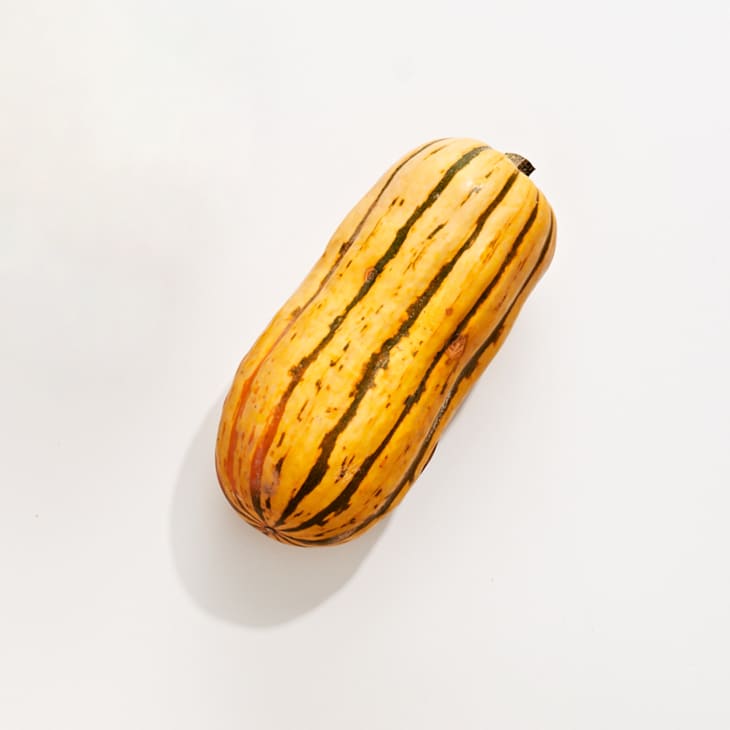 Delicata squash on a white surface.