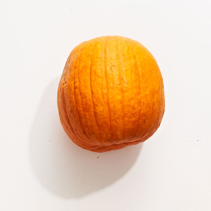Sugar pumpkin squash on a white surface.