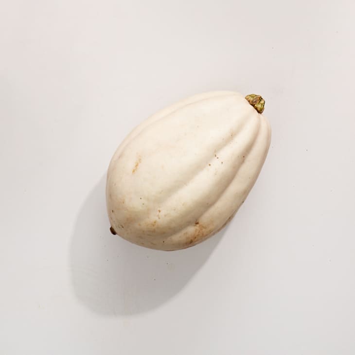 White acorn squash on a white surface.