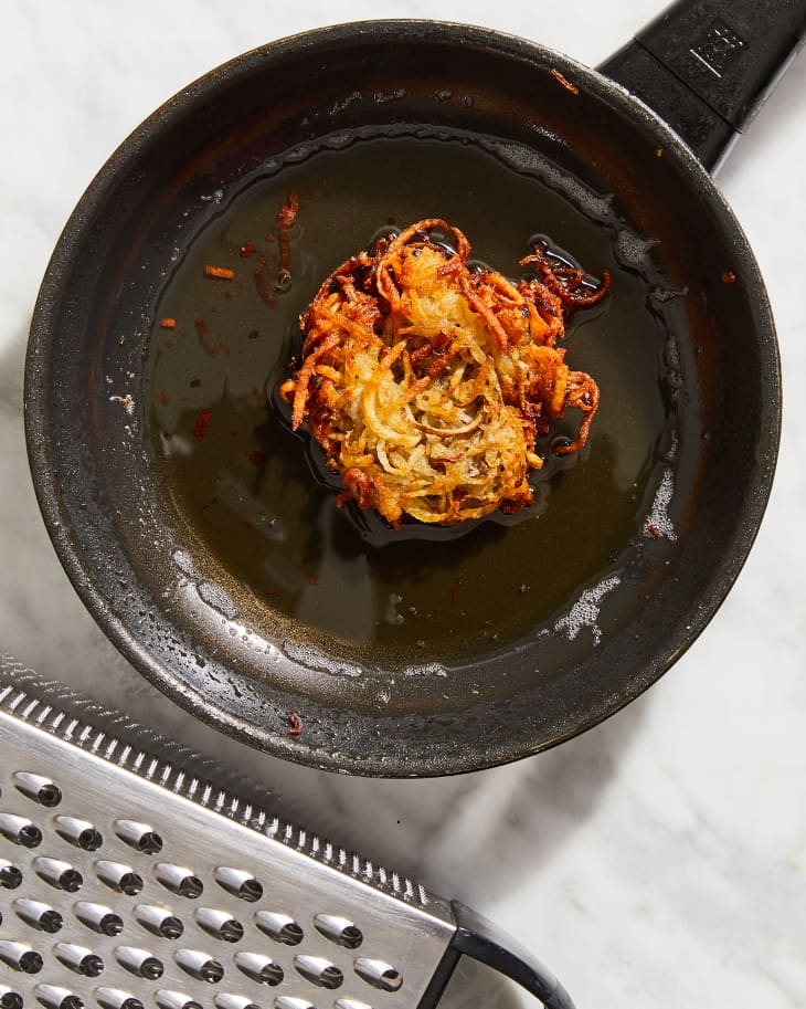 latke in pan with cheese grater