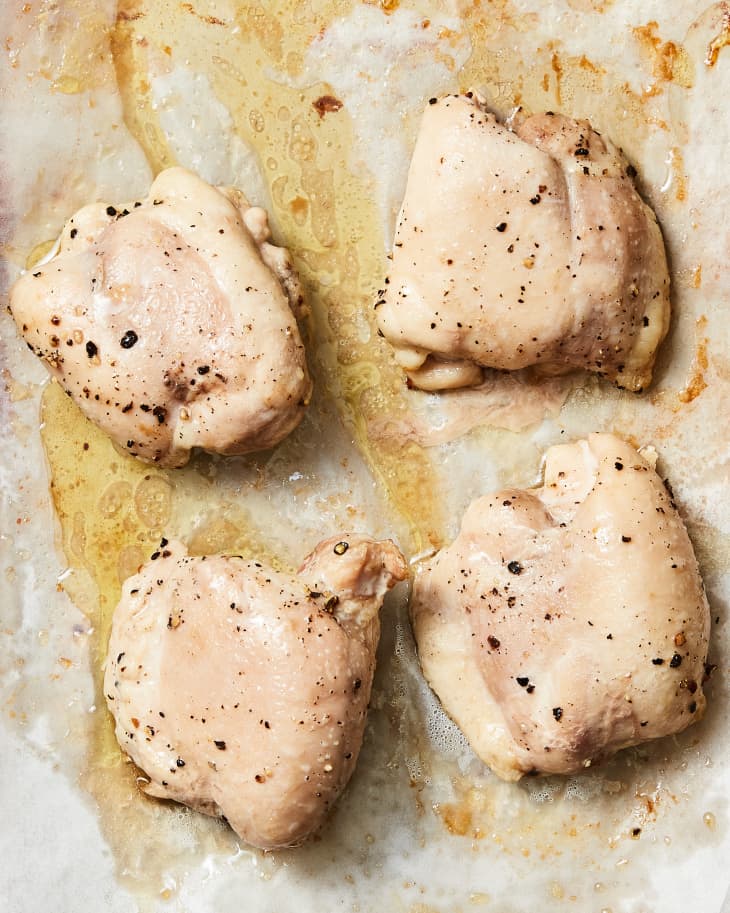Overhead photo of boneless skinless chicken thighs roasted on baking sheet