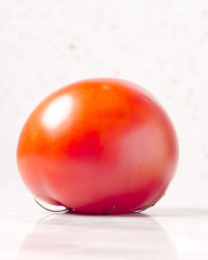 photo of a beefsteak tomato with the stem side down on a marble surface