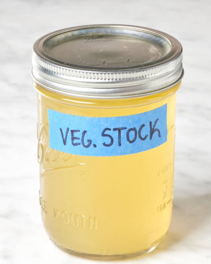 Head on view of a mason jar of stock, with a label that reads "veg. stock".