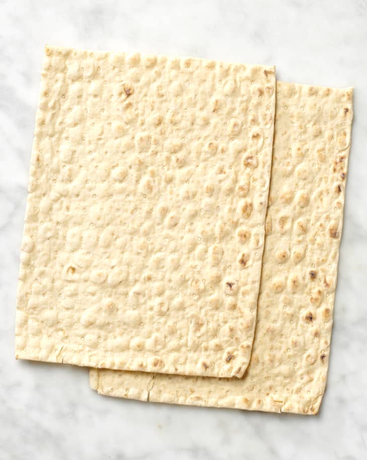 Overhead view of two pieces of lavash bread on a marble surface.