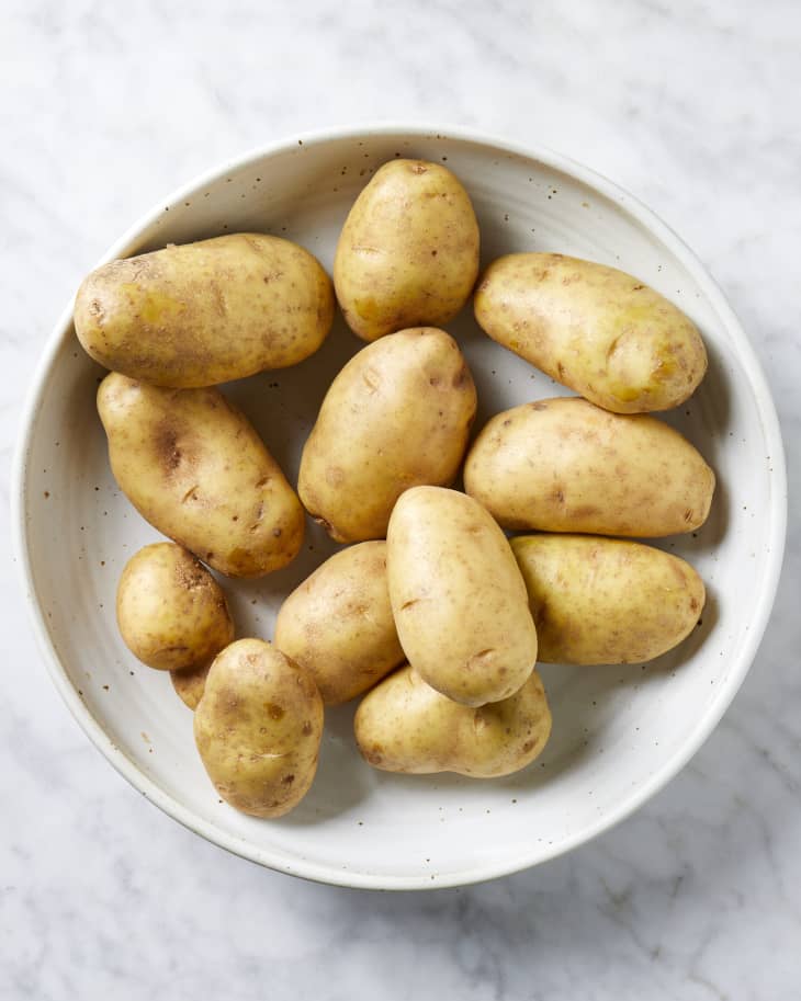 Overhead view of potatoes in a white bowl.