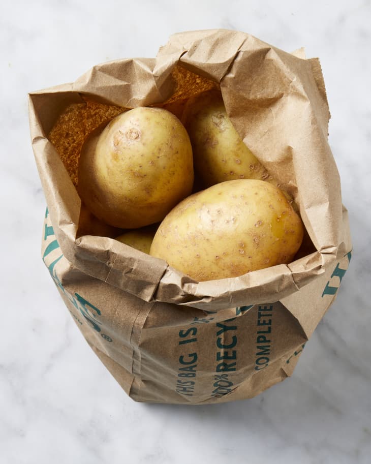 Overhead view of potatoes in a paper bag.