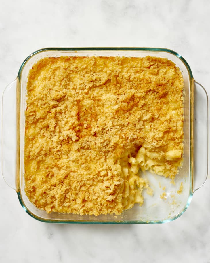 Overhead view of mac and cheese in a square, glass baking dish, with a scoop taken out of the bottom right corner.