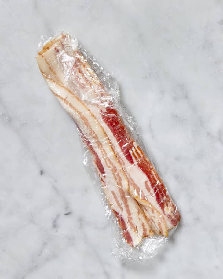 Overhead shot of bacon wrapped in plastic wrap.