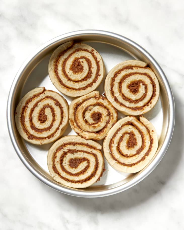 Overhead shot of unbaked cinnamon rolls in a cake pan.