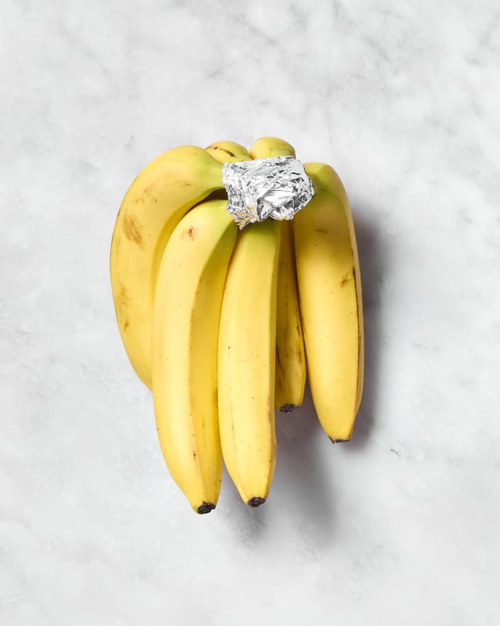 shot of a bunch of bananas with tin foil on the stem.