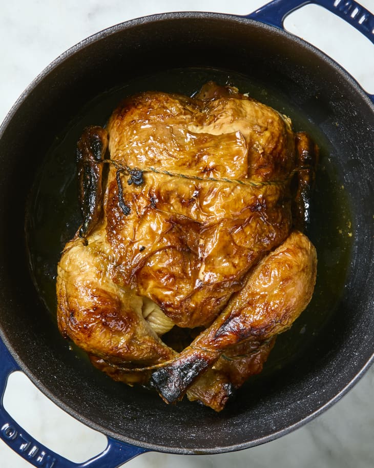 overhead shot of a rotisserie chicken in a dutch oven.