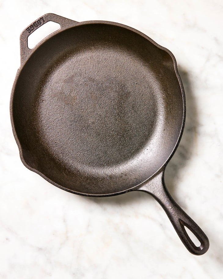 A nicely seasoned and clear cast iron skillet on a marble surface