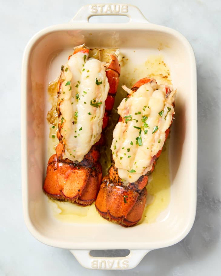 overhead shot of two lobster tails in a small white baking dish.