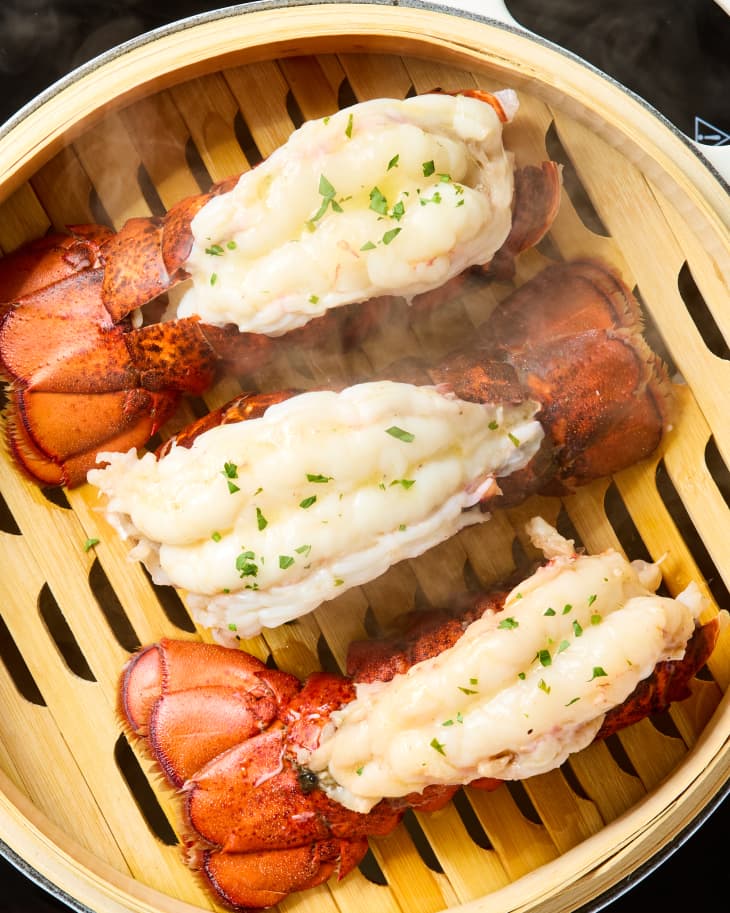 overhead shot of three lobster tails in a steaming basket.