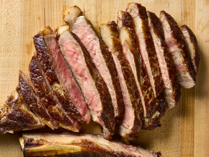 overhead shot of a full steak slice on a wooden cutting board.