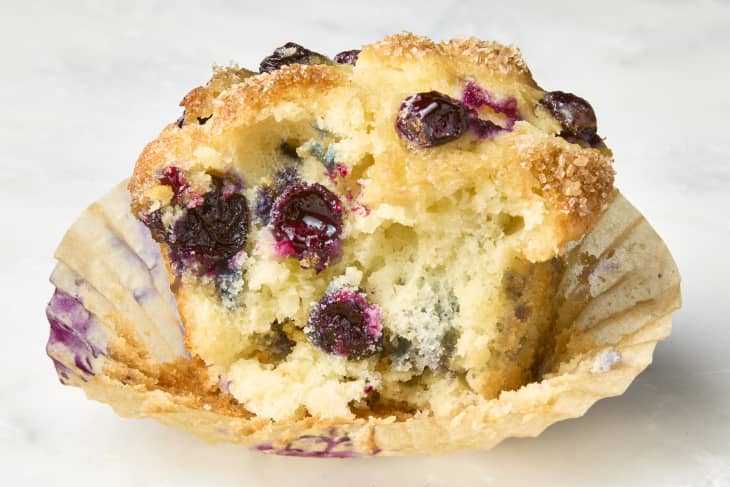 head on shot of the Smitten Kitchen blueberry muffin with a bite taken out of it.