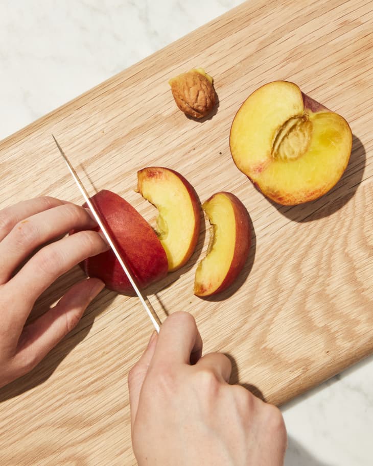 Slicing peach on cutting board