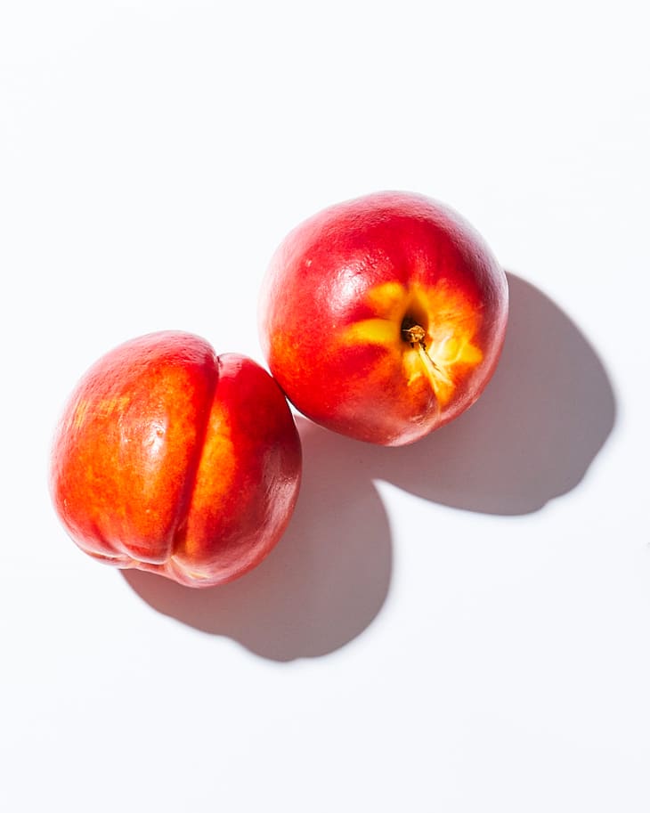 Nectarines on a white surface
