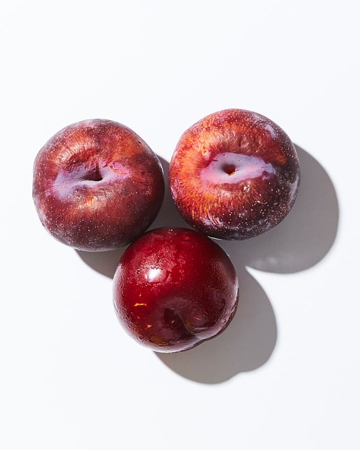 Plums on a white surface