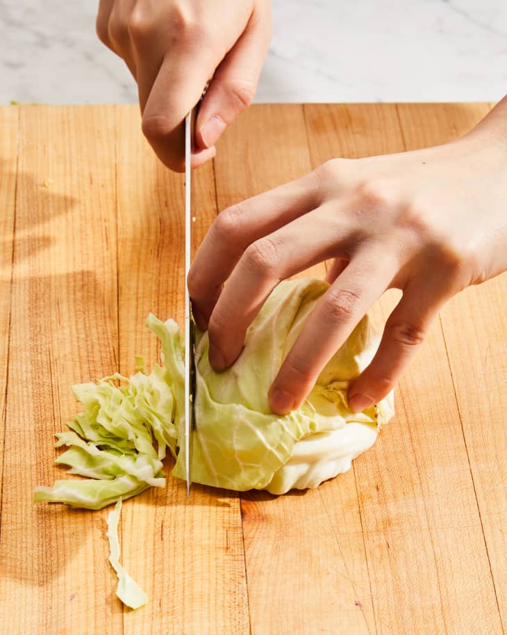 Someone slicing cabbage.