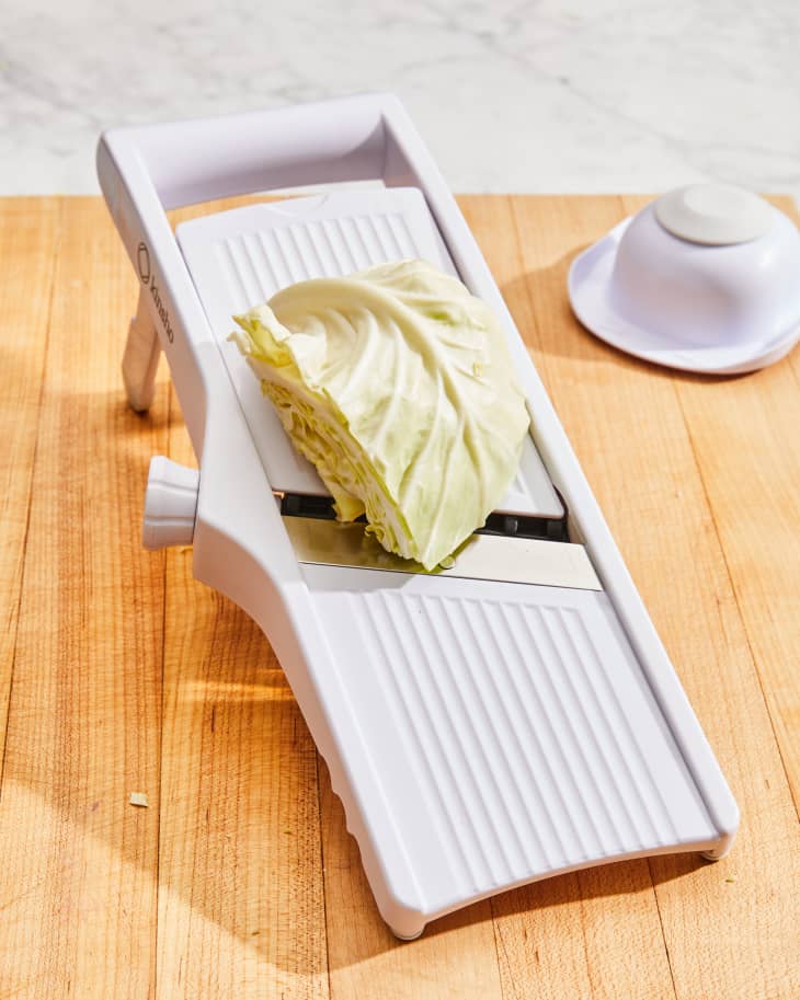 Depiction of the instructions in How to Cut and Shred Cabbage with a Mandoline Slicer  step 1