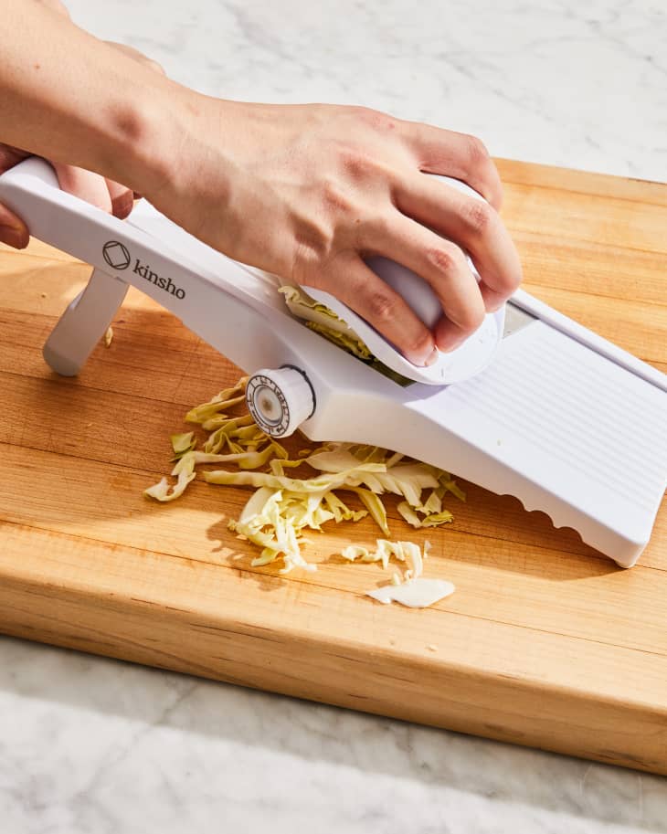 Depiction of the instructions in How to Cut and Shred Cabbage with a Mandoline Slicer  step 2