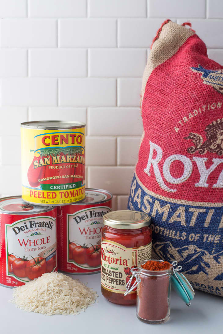 Ingredients for Jamie Oliver's chili-pork goulash recipe: a can of Cento San Marzano peeled tomatoes, two cans of Dei Fratelli whole tomatoes, Victoria roasted red peppers, chili in a small jar, Basmati rice