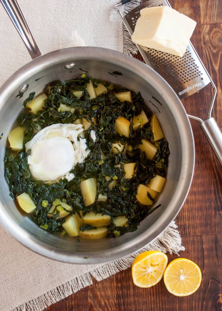 Kale and cubed potatoes with a poached egg in a pot