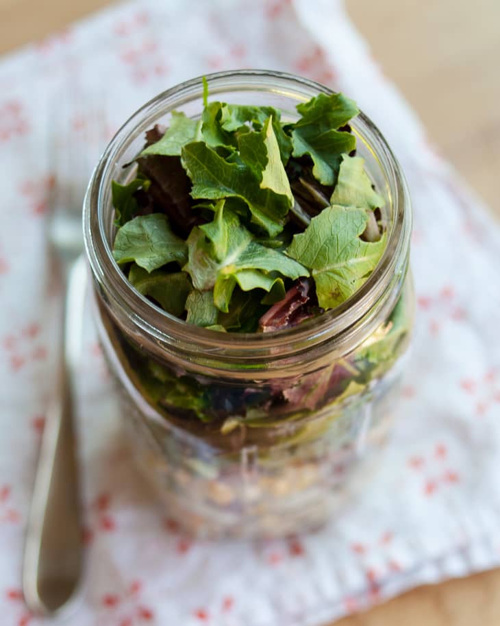 A top shot of salad in a jar, focusing on fresh greens