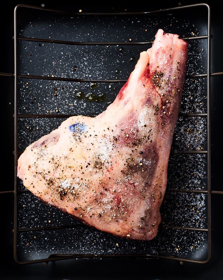 A raw leg of lamb on a roasting tray