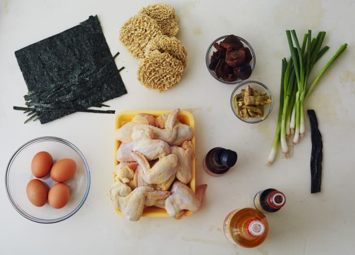 Ingredients for ramen, left to right: seaweed, dried noodles, shiitake mushrooms, scallions, kombu, sesame oil, soy sauce, mirin eggs, bone-in chicken, and eggs