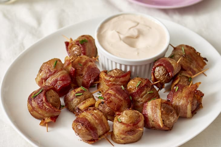 Bacon-wrapped potato bites served with dipping sauce