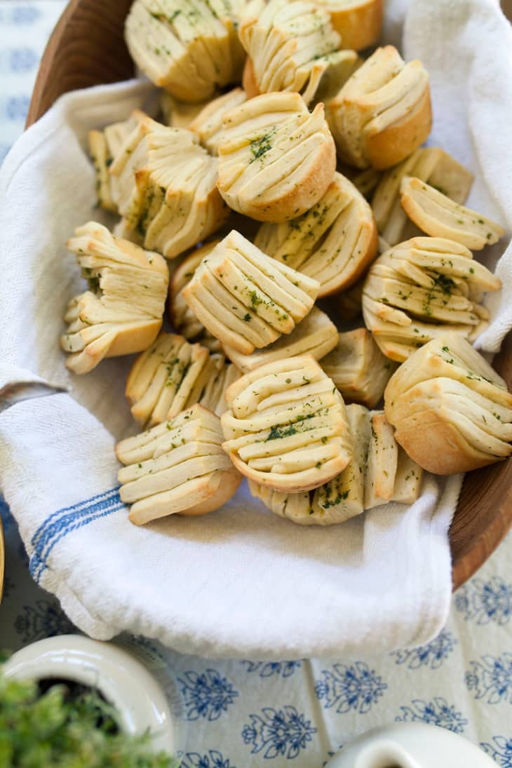 Herbed olive oil fantail roll on a towel over a wooden bread basket